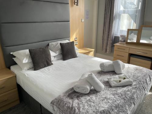a bedroom with a large bed with towels on it at The Wildings Hotel & Tudno's Restaurant in Llandudno