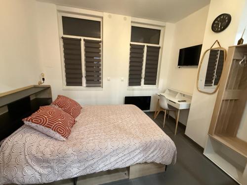 - une chambre avec un lit, un bureau et une horloge dans l'établissement Apartment Lille-Fives, à Lille