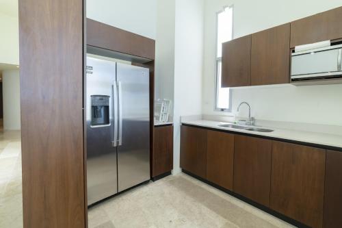 a kitchen with a stainless steel refrigerator and a sink at Temporada B52 in Telchac Puerto