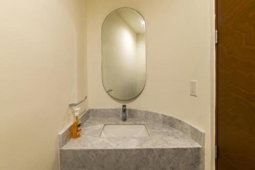 a bathroom with a sink with a round mirror at Temporada B52 in Telchac Puerto