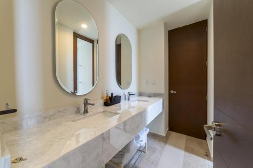 a bathroom with two sinks and two mirrors at Temporada B52 in Telchac Puerto