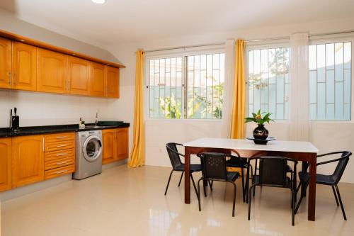 Una cocina con una mesa y sillas en una cocina. en Praia Guest House, en Praia