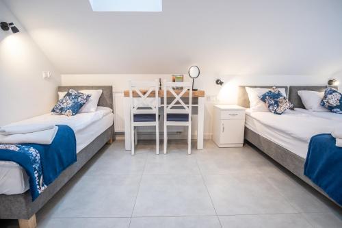 a bedroom with two beds and a desk in it at Azymut 48C in Stary Folwark