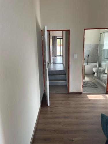 an empty room with a hallway with a tub and a bathroom at The Gorge View at Highland Gate in Dullstroom