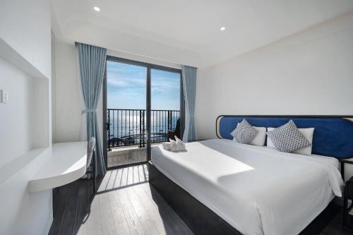 a bedroom with a large bed and a balcony at La isla Apartments & Villas - Sea View & Fireworks Phu Quoc in Phu Quoc