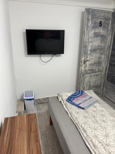 a room with a bed and a flat screen tv on a wall at Centrum Apartman in Debrecen