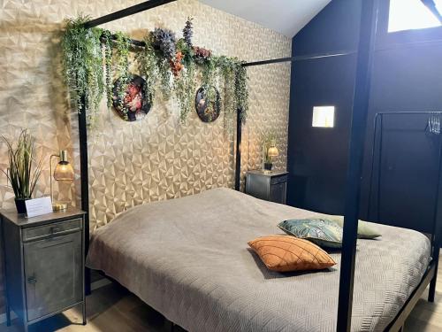 a bedroom with a four poster bed with plants on it at Gîte "Le Loft" in Chamblet