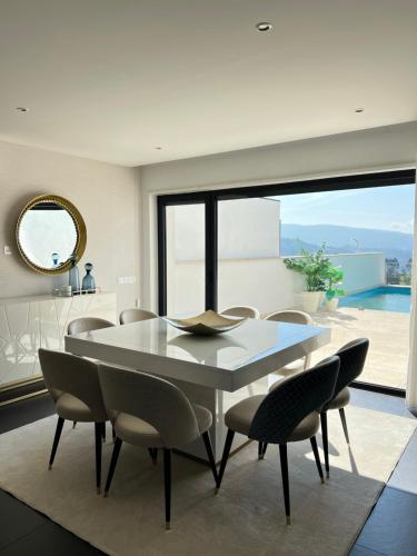 a dining room with a white table and chairs at Moradia Vila Golfe in Amarante