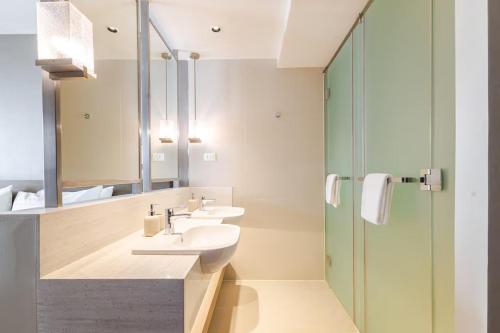 a bathroom with two sinks and a shower at Novotel Executive Suite - Acqua Manila Khendra in Manila
