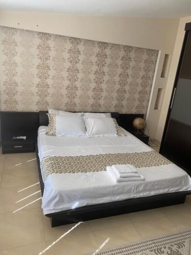 a bedroom with a large bed with a wall at Мезонет “Djanina” in Sandanski