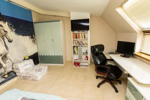 an office with a desk and a chair and a computer at Мезонет “Djanina” in Sandanski