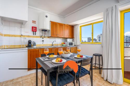 a kitchen and dining room with a table and chairs at #303 Atlantida Praia da Rocha by Home Holidays in Portimão