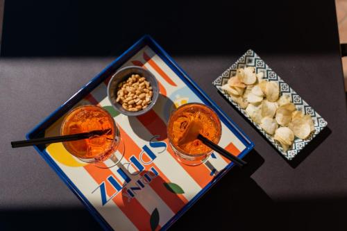 a table with two drinks and a plate of food at Spa Hotel Splendid Sole in Manerba del Garda