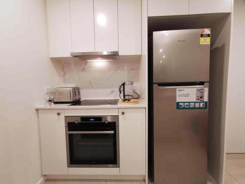 a small kitchen with a stainless steel refrigerator at Archer Apartment 2br with free car space in Kingston