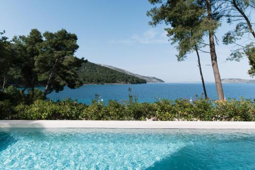 a swimming pool with a view of the water at Maslinica Maison Collection in Stari Grad