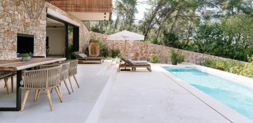 a patio with a table and chairs next to a swimming pool at Maslinica Maison Collection in Stari Grad