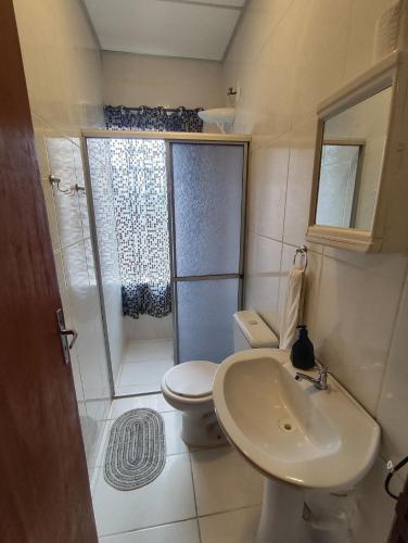 a bathroom with a shower and a toilet and a sink at Villa Bilac - Amplos Studios 2km da Vila Germânica in Blumenau