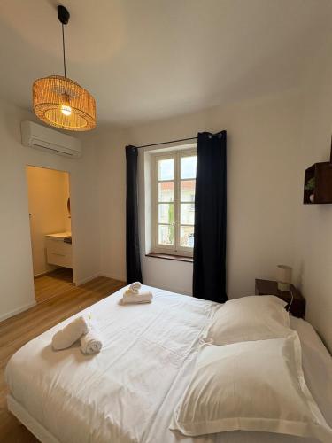 une chambre avec un lit blanc avec deux serviettes dessus dans l'établissement L'apparté Arles centre, à Arles