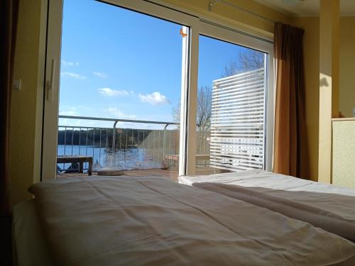 a bedroom with a bed and a large window at Eisvogel Classic 301 in Granzow