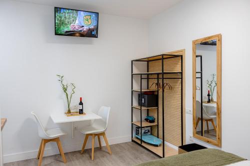 a room with a table and chairs and a mirror at Bambú Suites Vegueta Alquiler por Habitación in Las Palmas de Gran Canaria
