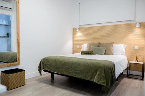 a bedroom with a large bed with a wooden headboard at Bambú Suites Vegueta Alquiler por Habitación in Las Palmas de Gran Canaria