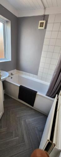 a bathroom with a bath tub and a sink at Sea Glass Cottage in Sunderland