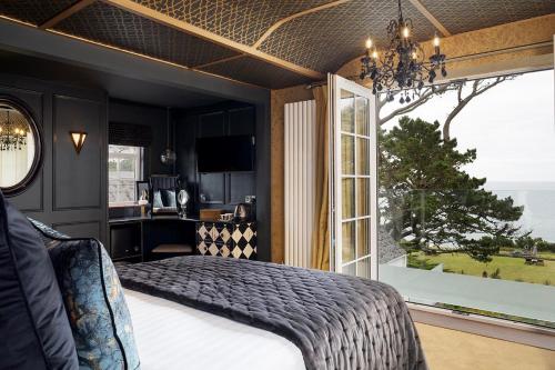 a bedroom with a bed and a large window at Talland Bay Hotel, Looe in Talland