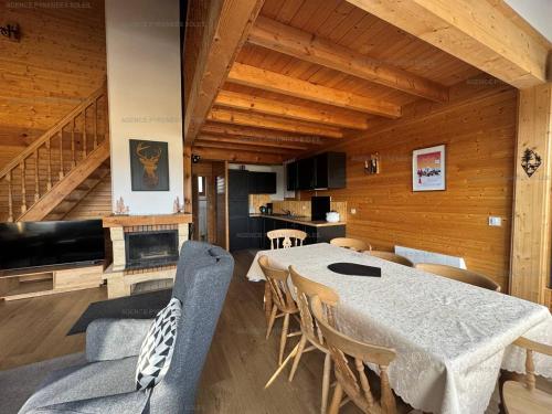 une salle à manger avec une table et quelques chaises dans l'établissement Chalet rénové 8 pers. avec cheminée et Wifi - FR-1-295-147, aux Angles