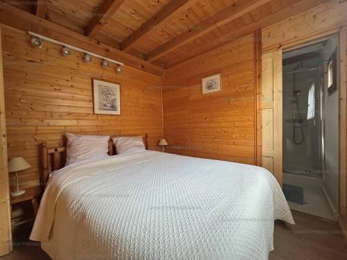 une chambre avec un lit dans une cabane en bois dans l'établissement Chalet rénové 8 pers. avec cheminée et Wifi - FR-1-295-147, aux Angles