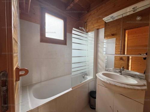 une salle de bain avec un lavabo et une baignoire dans l'établissement Chalet rénové 8 pers. avec cheminée et Wifi - FR-1-295-147, aux Angles