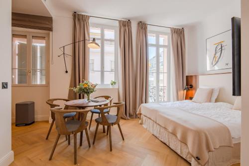 une chambre avec un lit, une table et des chaises dans l'établissement La Guitare 21 - Cozy studio in center of Cannes, just behind Grand Hotel, à Cannes