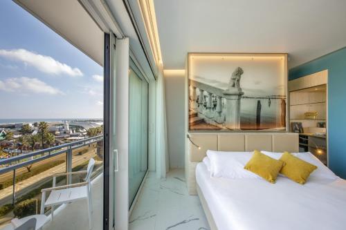 a bedroom with a bed and a large window at Ambasciatori Suite Hotel in Sottomarina