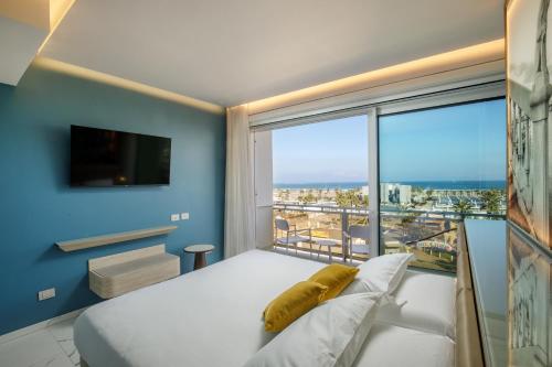 a bedroom with a bed and a large window at Ambasciatori Suite Hotel in Sottomarina