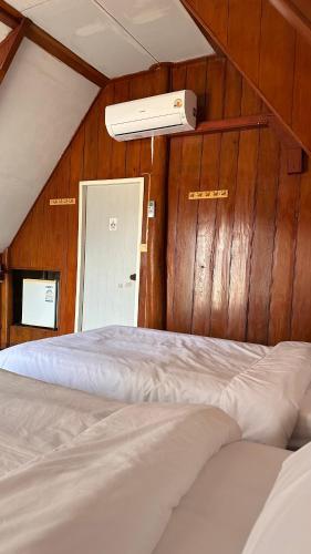 a bedroom with two beds and a air conditioner on the wall at Mae Chaem Hotel and Resort in Mae Chaem