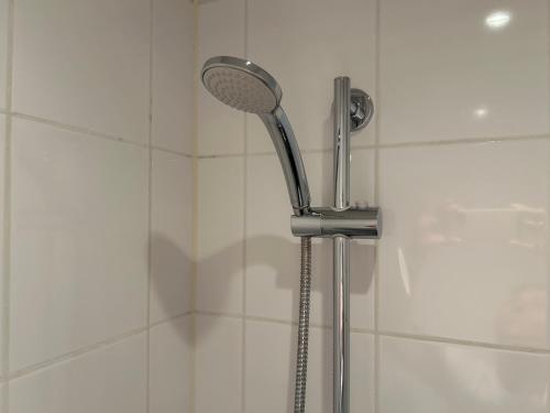 a shower with a shower head in a bathroom at Warmhuisje in Warmenhuizen