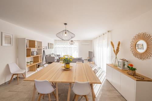 une salle à manger et un salon avec une table et des chaises dans l'établissement Nouveau ! Villa des vignes Piscine & Clim, à Salavas