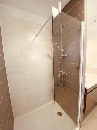 une douche avec une porte vitrée dans une salle de bain dans l'établissement T2 climatise 4 pers avec terrasse vue campagne piscine et parking V0773, à Vias