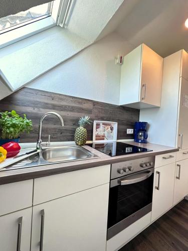 a kitchen with white cabinets and a sink at Ferienwohnung Leuchtfeuer Dagebüll in Dagebüll