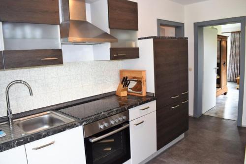 eine Küche mit Spüle und Herd oberen Backofen in der Unterkunft Haus Storjohann Dagebüll in Dagebüll