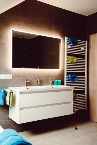a bathroom with a white sink and a mirror at Ferienhaus Gîte Al Scheier Tarchamps in Tarchamps