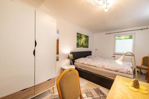 a bedroom with a bed and a desk and a table at Waldpark Krätzersrasen FH3 in Bad Liebenstein