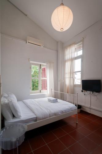 a white bedroom with a bed and a window at Aayu Church St - 7 mins to Esplanade, George Town in George Town