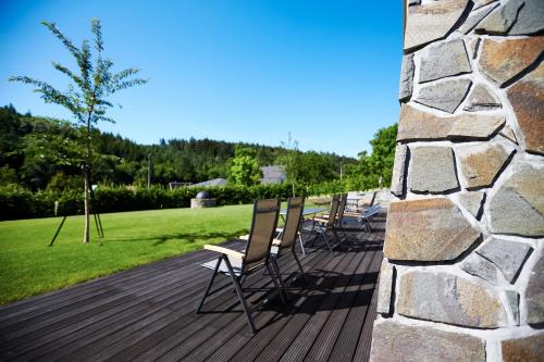 a row of chairs sitting on a wooden deck at Pension Ježník in Krnov
