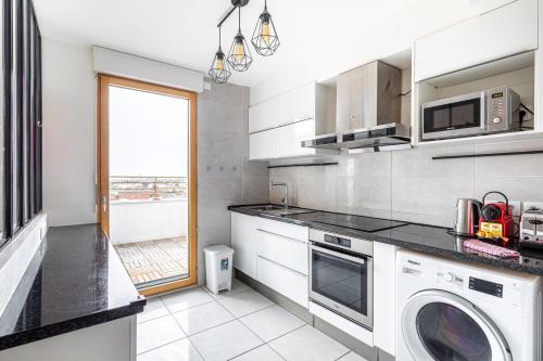 une cuisine avec laveuse et sécheuse dans l'établissement GuestReady - Architect-Designed Retreat near Paris, à Aubervilliers