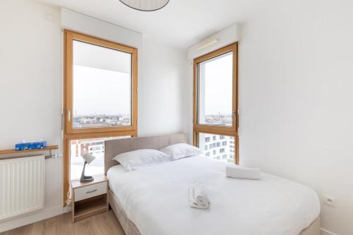 une chambre avec deux lits et deux fenêtres dans l'établissement GuestReady - Architect-Designed Retreat near Paris, à Aubervilliers