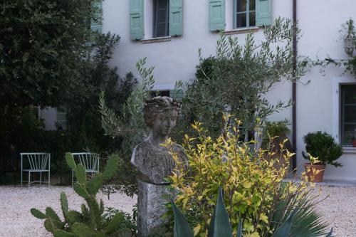 a statue in a garden in front of a building at Residenza Paulonia in Volta Mantovana