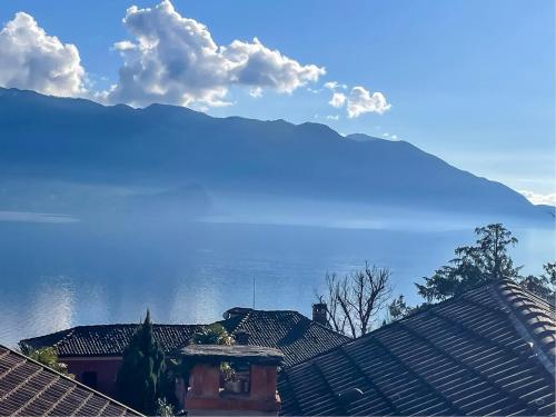 una vista de los tejados de las casas con montañas en el fondo en Casa delle Antiche Pietre, en Cannero Riviera