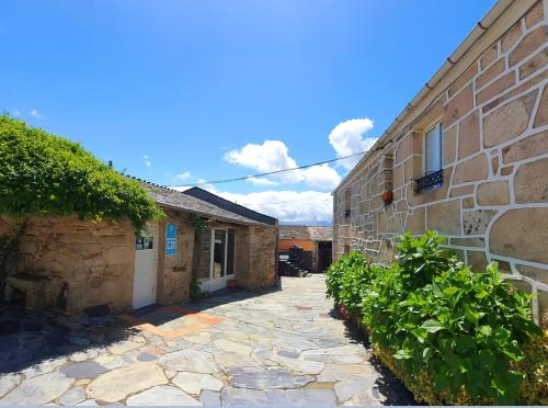 a stone walkway next to a brick building at A casa de Carmen in Sarria