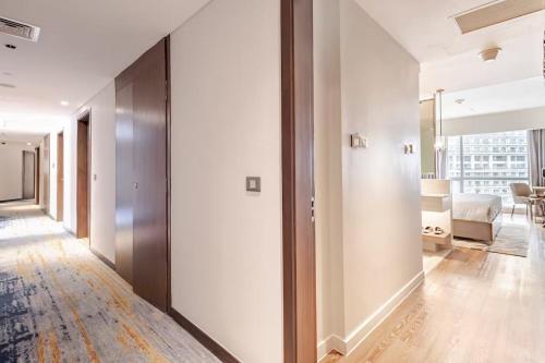 a hallway with white walls and a living room at Novotel Executive Suite - Acqua Manila Khendra in Manila