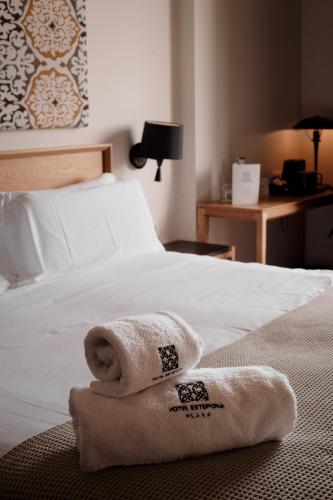 a hotel room with a bed with towels on it at Hotel Estepona Plaza in Estepona